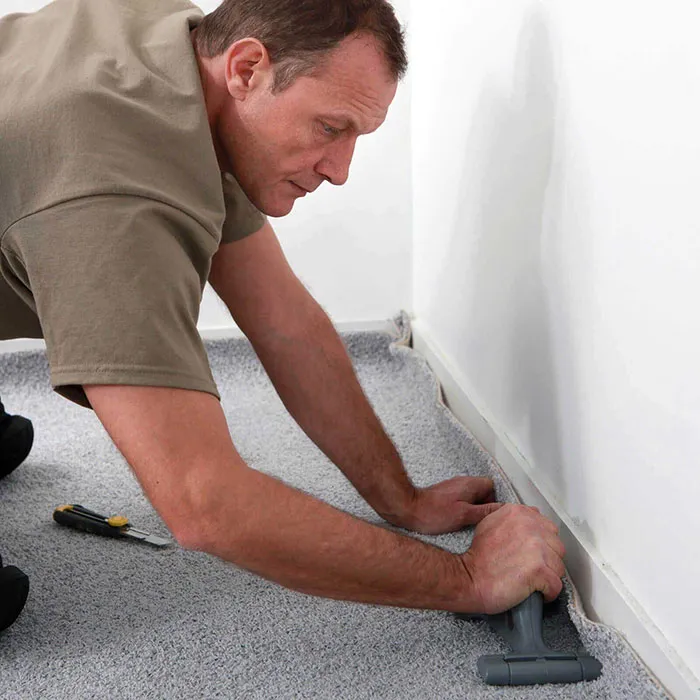 Worker installing carpet | Off-Price Carpet Outlet
